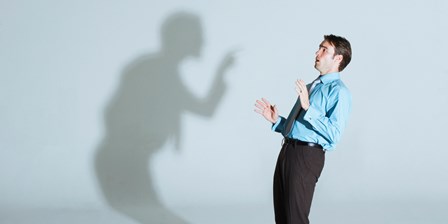 Businessman being scolded by his shadow
